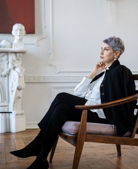 Woman practicing mindful breathing in a calm, modern office setting.